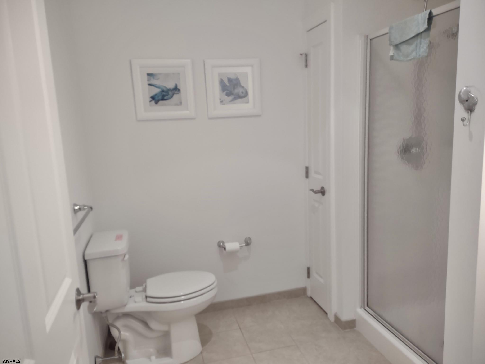 810 Asbury Avenue, Unit 303 Ocean City, NJ 08226 - Photo 8 of 20 a bathroom with a toilet and a shower