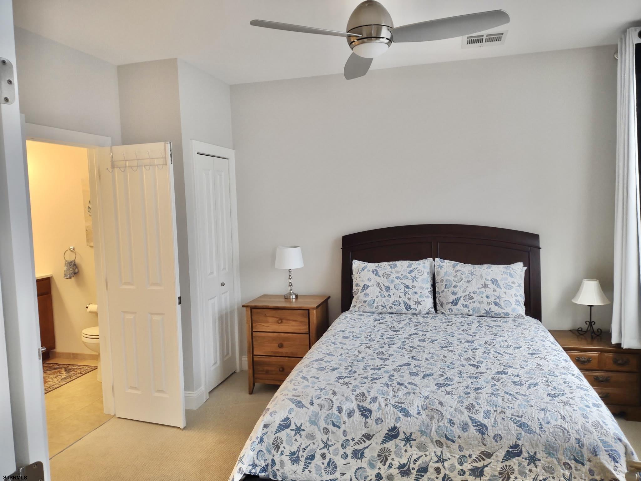 810 Asbury Avenue, Unit 303 Ocean City, NJ 08226 - Photo 10 of 20 a bedroom with a large bed and a chandelier