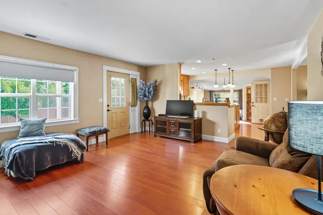 a living room with furniture and a flat screen tv with wooden floor