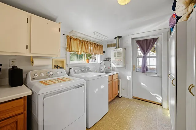 a utility room with cabinets washer and dryer