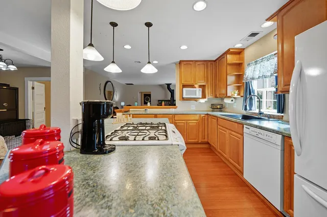 a kitchen with stainless steel appliances granite countertop a stove a sink and a refrigerator