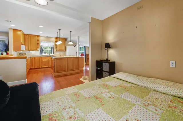 a large bedroom with a bed and wooden floor