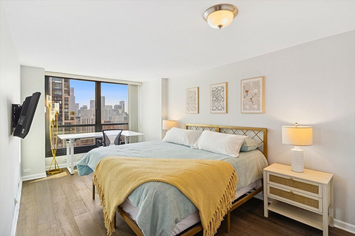 1030 North State Street, Unit 33GH Chicago, IL 60610 - Photo 10 of 26 a bedroom with a bed a couch and a window