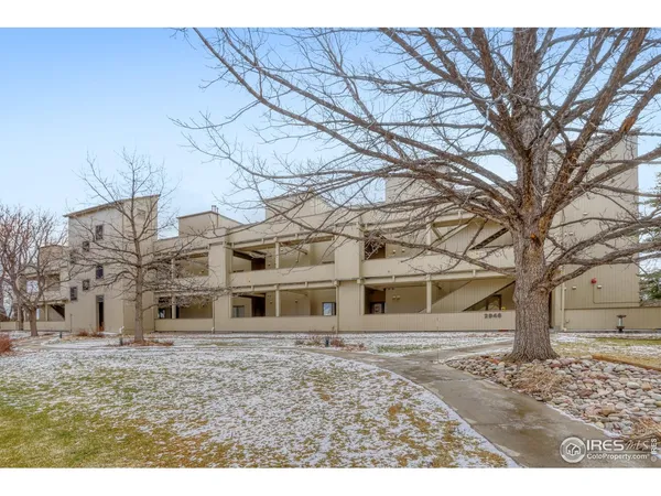 a view of a large white house with a large tree