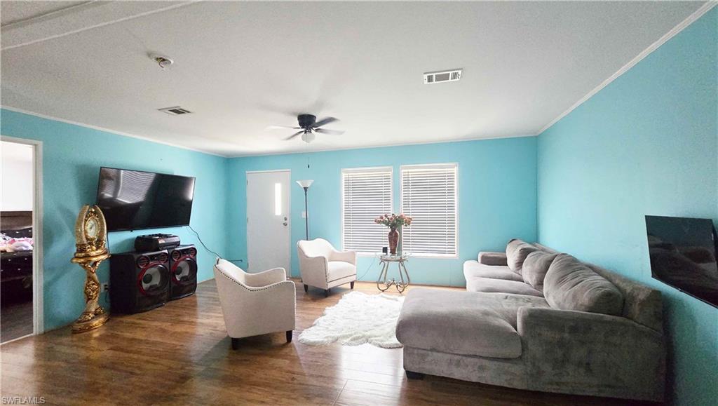 612 Hunting Clb Avenue Montura Ranches, FL 33440 - Photo 22 of 49 a living room with furniture and a flat screen tv