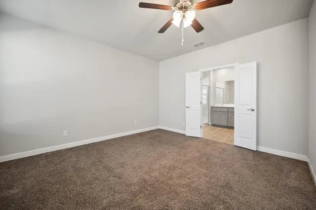 an empty room with fan and entrance