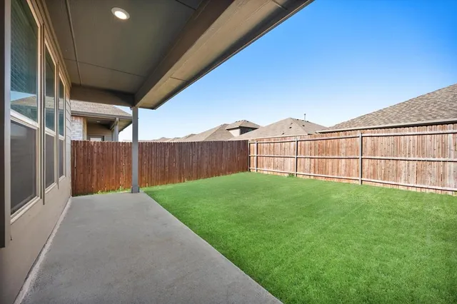 a view of a backyard with wooden fence