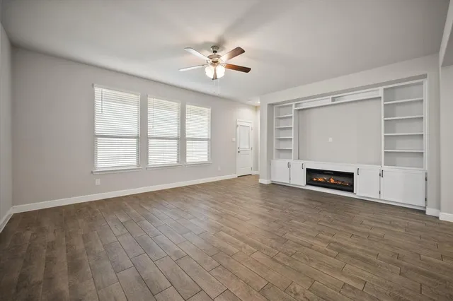 wooden floor fireplace and windows in an empty room