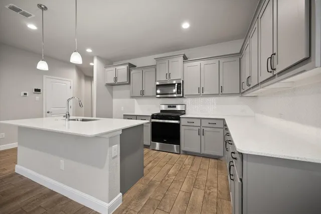 a kitchen with kitchen island a sink stainless steel appliances and cabinets