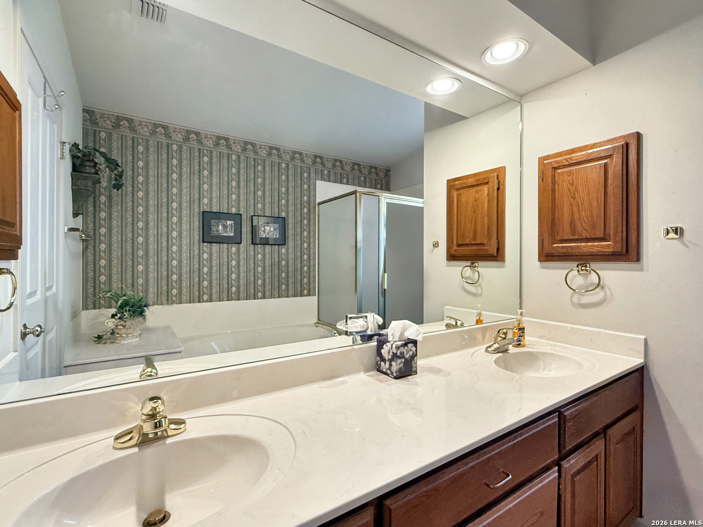 140 St Andrews Loop Kerrville, TX 78028 - Photo 12 of 24 a bathroom with a sink double vanity granite tub shower and a mirror