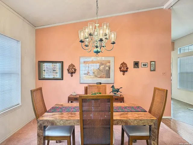 a dining room with furniture a chandelier and window