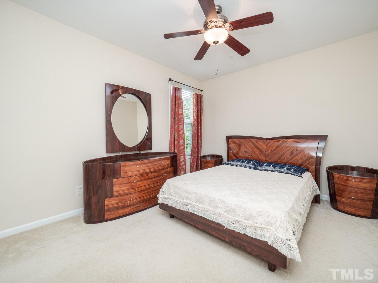 3016 Red Grape Drive Raleigh, NC 27607 - Photo 11 of 23 a bedroom with a bed dresser and a chandelier