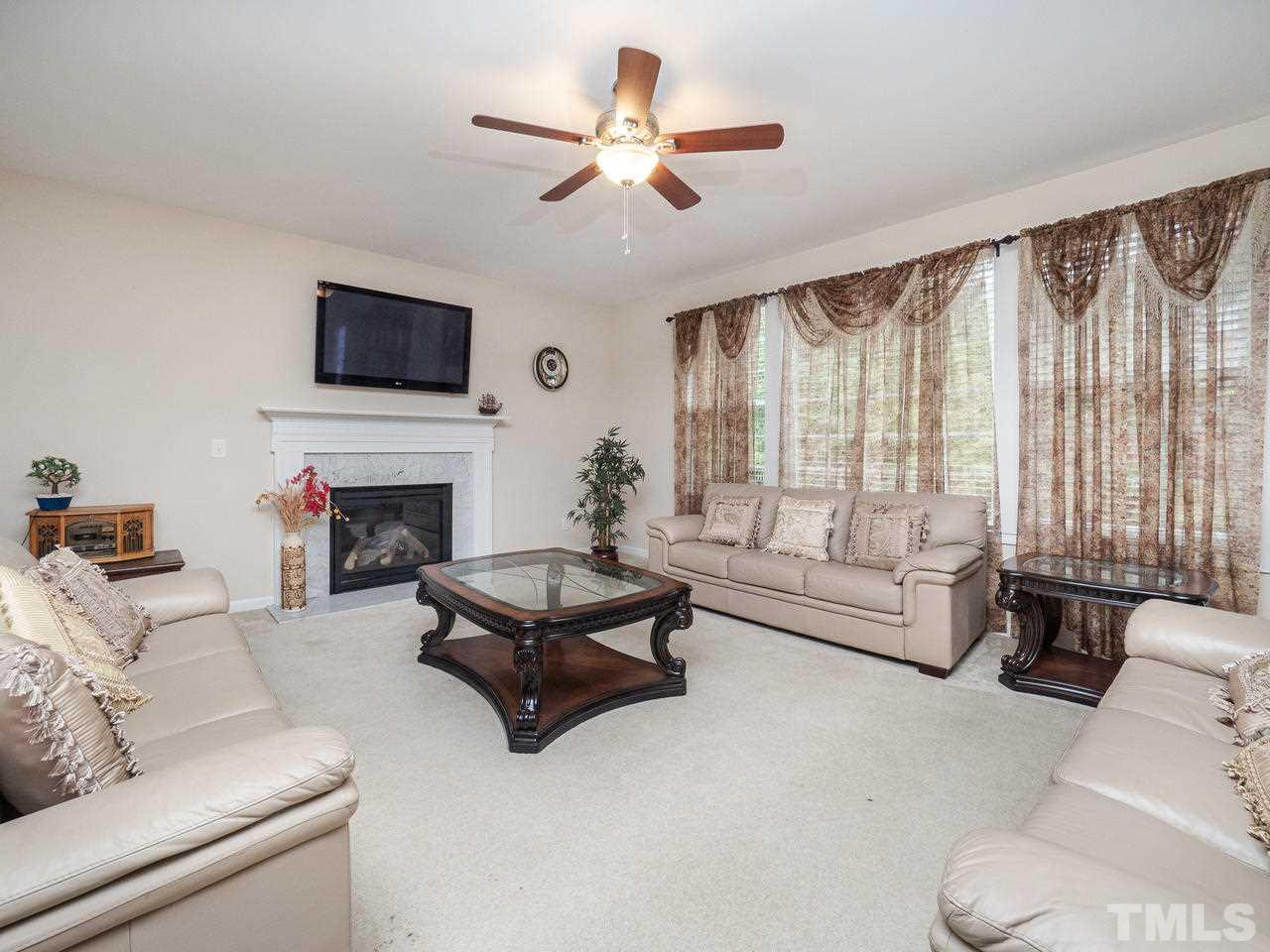 3016 Red Grape Drive Raleigh, NC 27607 - Photo 7 of 23 a living room with furniture a flat screen tv and a large window