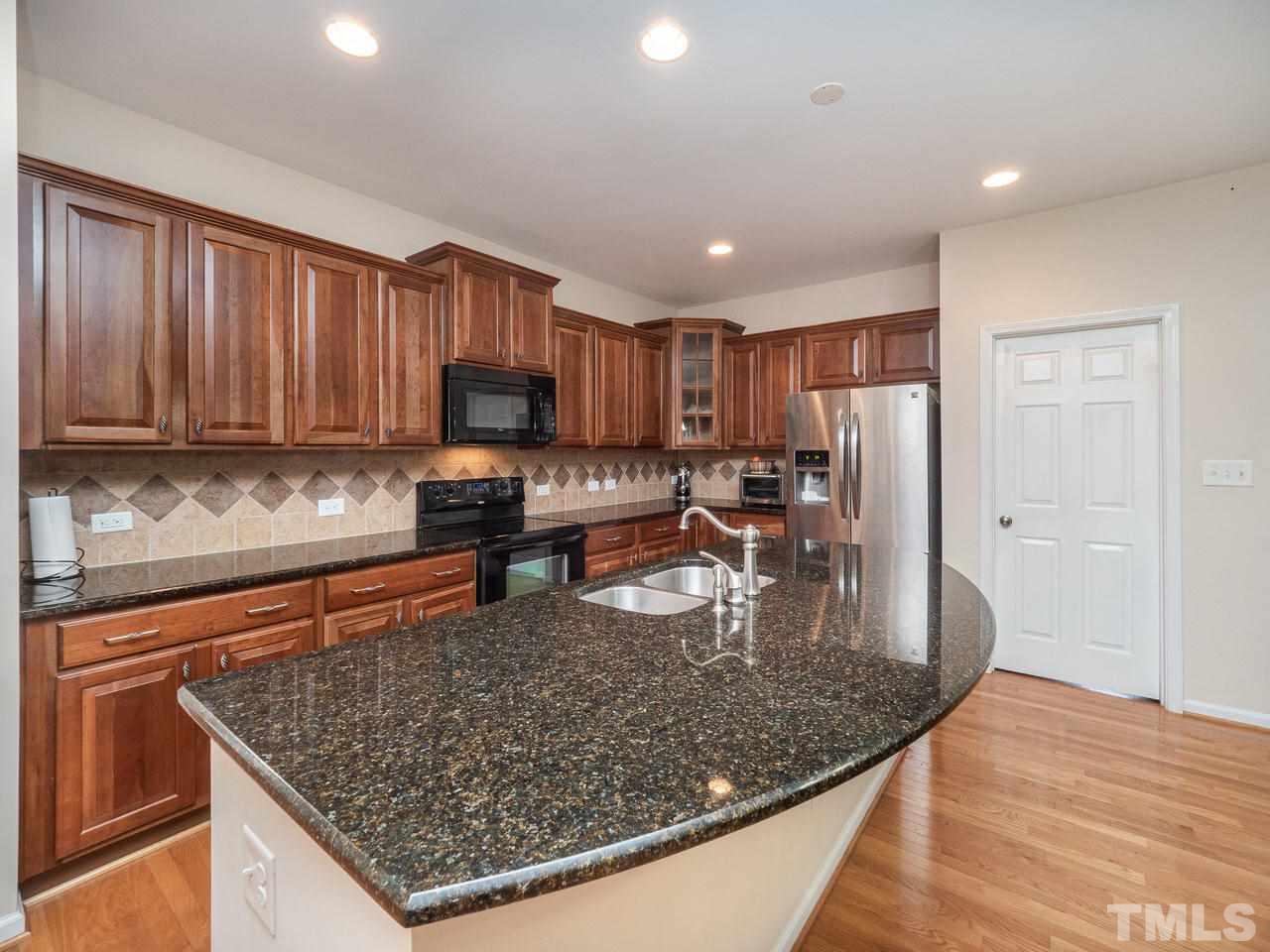 3016 Red Grape Drive Raleigh, NC 27607 - Photo 9 of 23 a kitchen with stainless steel appliances granite countertop a stove top oven a sink and a granite counter tops