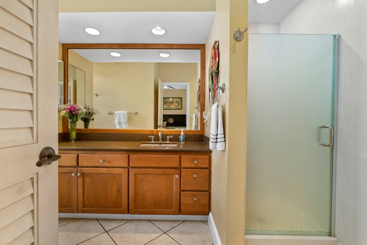 1565 Pe'e Road, Unit 211 Koloa, HI 96756 - Photo 19 of 30 a bathroom with a granite countertop sink and a mirror