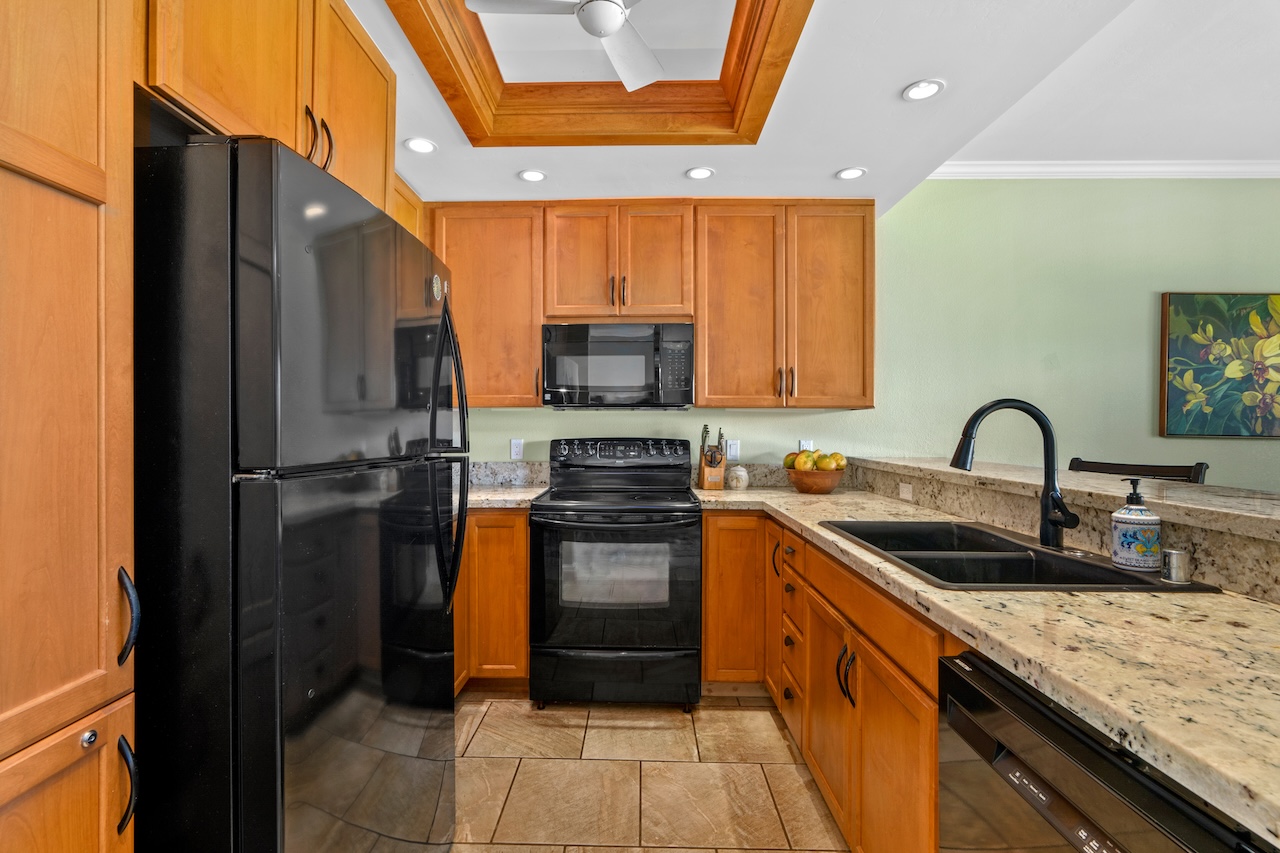 1565 Pe'e Road, Unit 211 Koloa, HI 96756 - Photo 7 of 30 a kitchen with stainless steel appliances granite countertop a refrigerator and a stove top oven