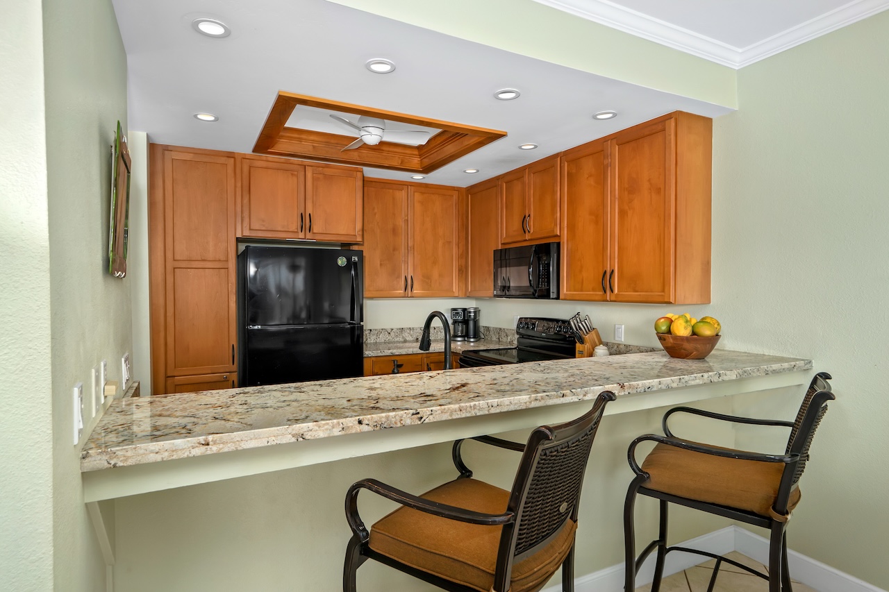 1565 Pe'e Road, Unit 211 Koloa, HI 96756 - Photo 8 of 30 a kitchen with stainless steel appliances granite countertop a sink and cabinets