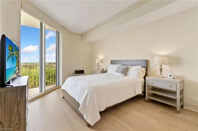 a large bedroom with a bed and a flat tv screen on dresser