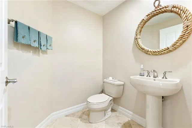 a bathroom with a sink mirror and toilet