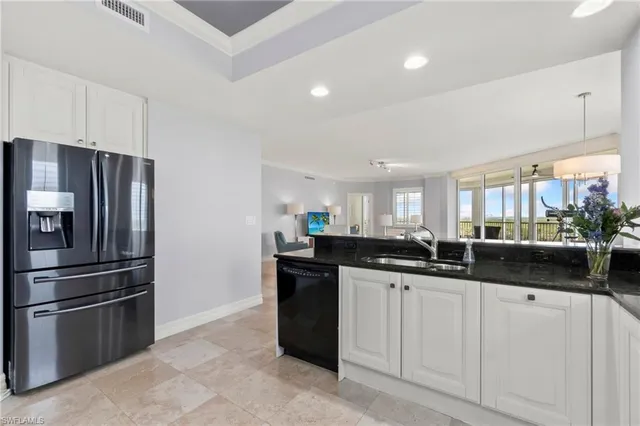 a kitchen with granite countertop a refrigerator and a sink