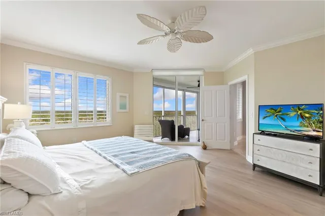 a bed room with a bed tv and a window