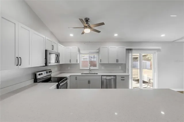 a kitchen with stainless steel appliances granite countertop a sink and cabinets