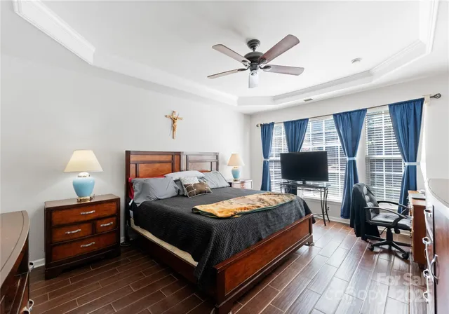 a bedroom with a bed a chandelier and a window