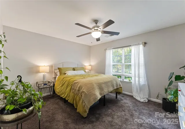 a bed sitting in a spacious bedroom next to a window