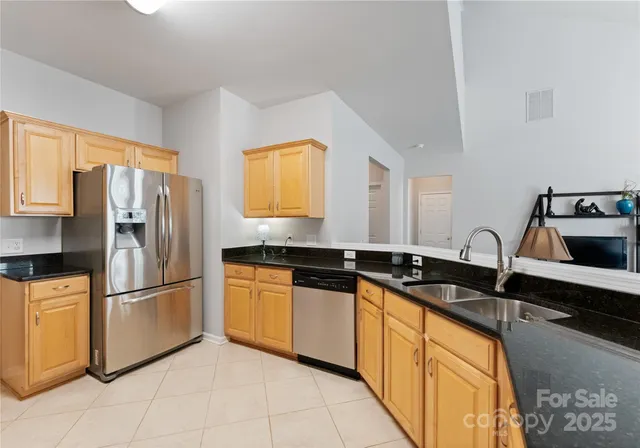 a kitchen with granite countertop a sink stainless steel appliances and cabinets