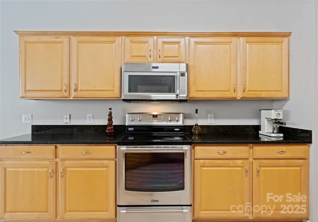 a kitchen with granite countertop cabinets stainless steel appliances and a sink