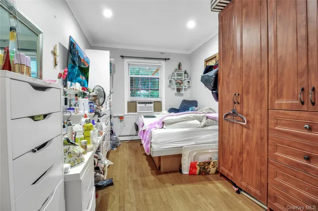 a bedroom with a bed a desk and chair with wooden floor