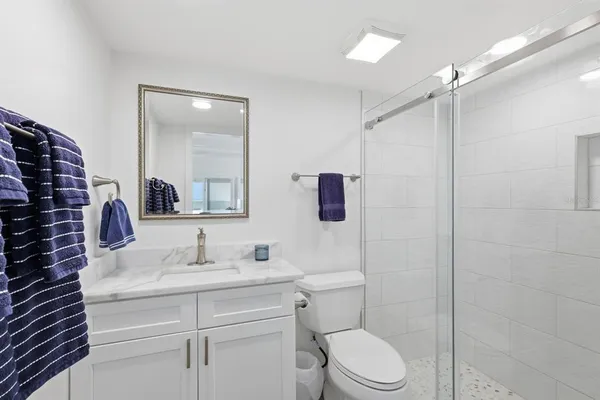 a bathroom with a sink toilet vanity and shower