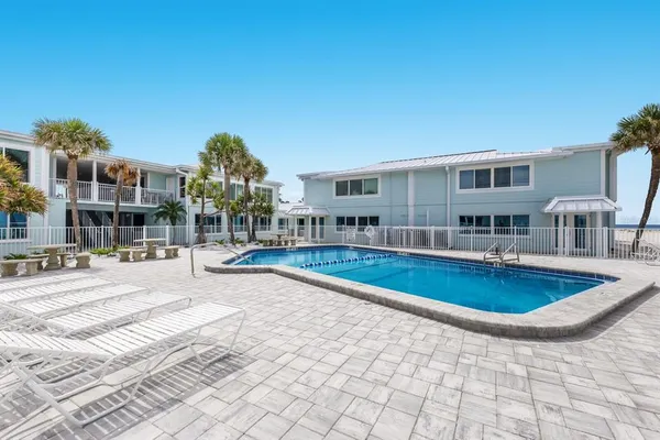 a view of a house with swimming pool and sitting area