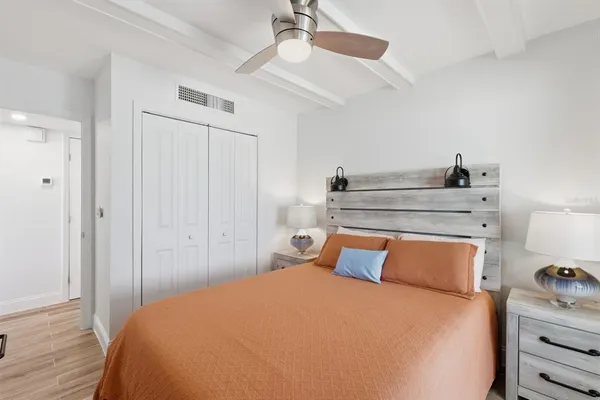 a bedroom with a bed and wooden floor