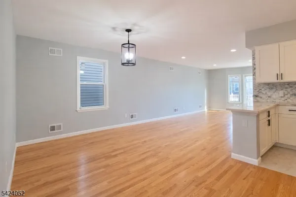 a view of empty room with kitchen and window