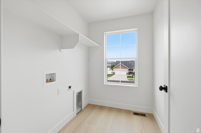 844 North 400 West Logan, UT 84321 - Photo 32 of 43 Bright laundry space featuring wood-finish flooring, a white-framed window, and built-in shelving