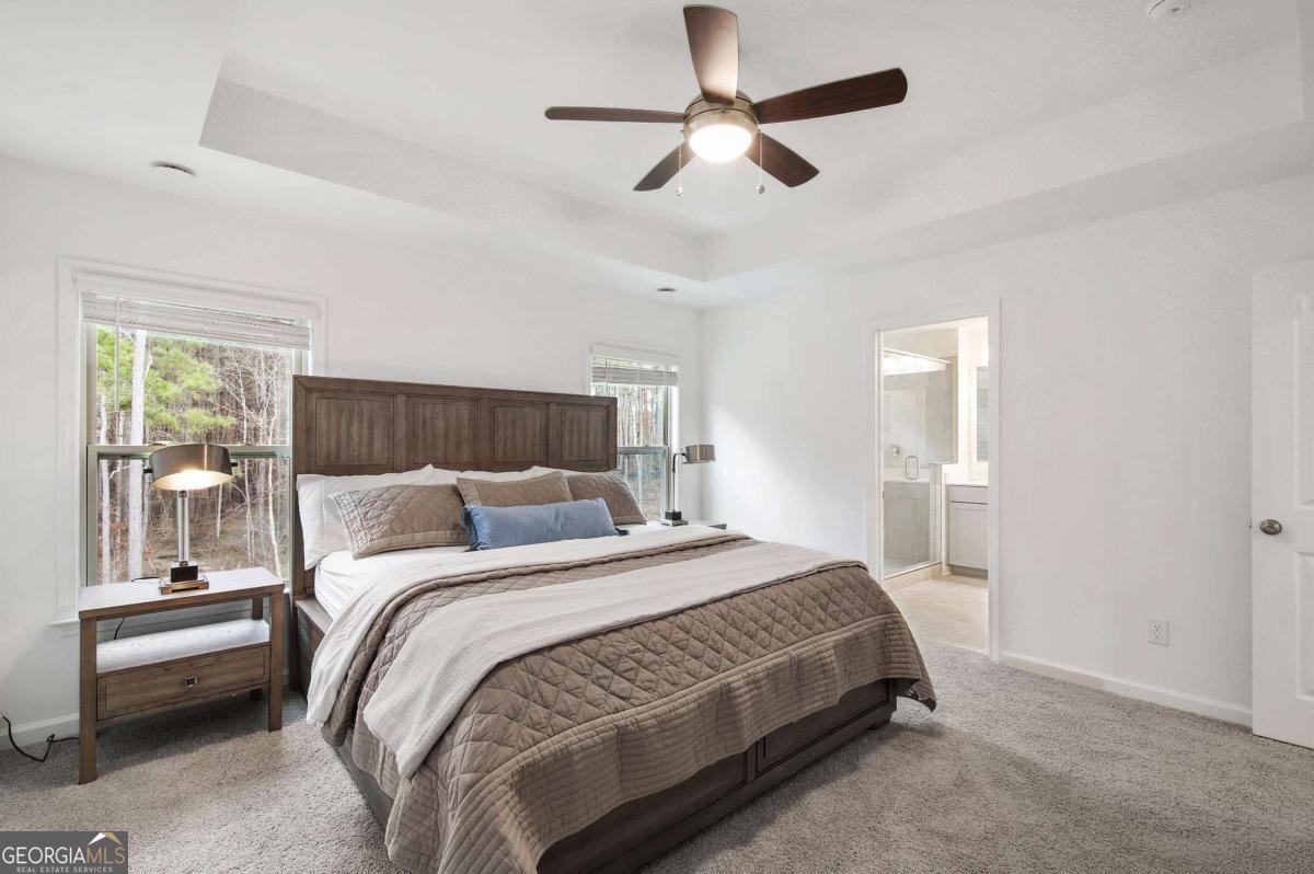 1526 Halstead Place, Unit 1526 Suwanee, GA 30024 - Photo 8 of 24 a bedroom with a bed and a chandelier