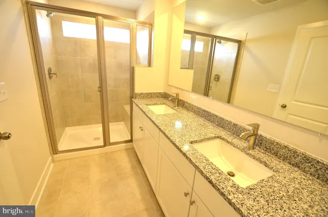 a spacious bathroom with a granite countertop shower and a sink