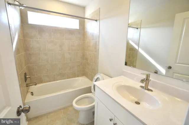 a bathroom with a sink mirror toilet and bathtub