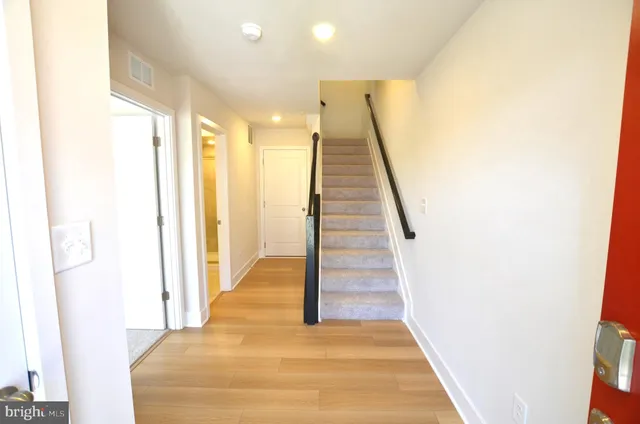 a view of a hallway with wooden floor and staircase
