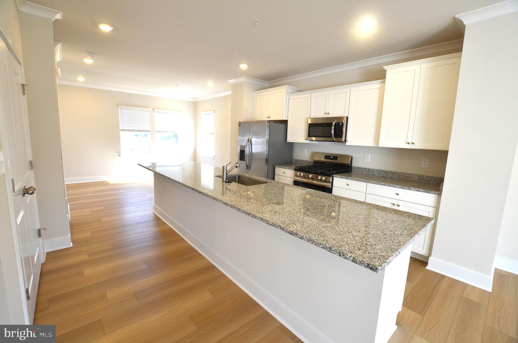 1832 Parham Way Baltimore, MD 21244 - Photo 5 of 25 a large kitchen with kitchen island a counter top space a sink and appliances