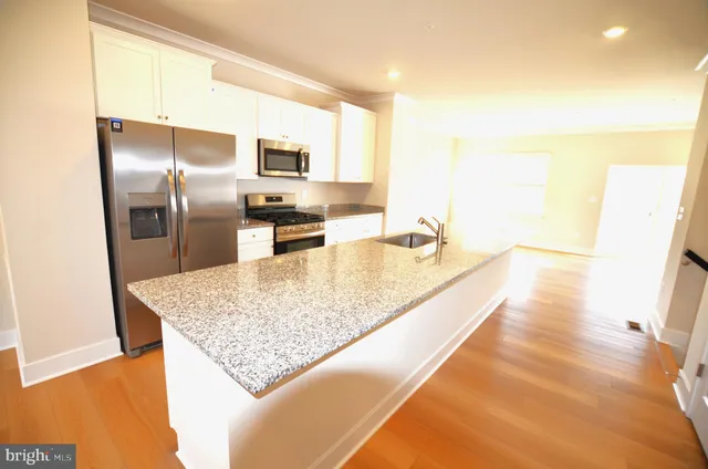 a kitchen with stainless steel appliances granite countertop a sink stove and refrigerator