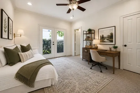 a bedroom with a bed a desk and chair with window