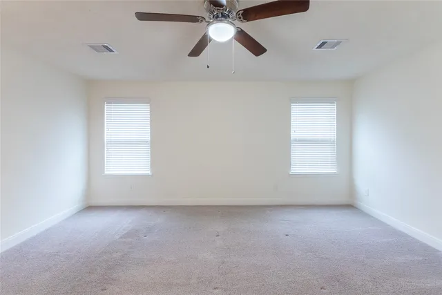 an empty room with chandelier fan
