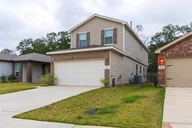 a front view of a house with a yard and garage