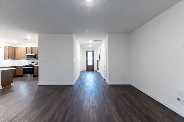 a view of a kitchen with wooden floor and electronic appliances