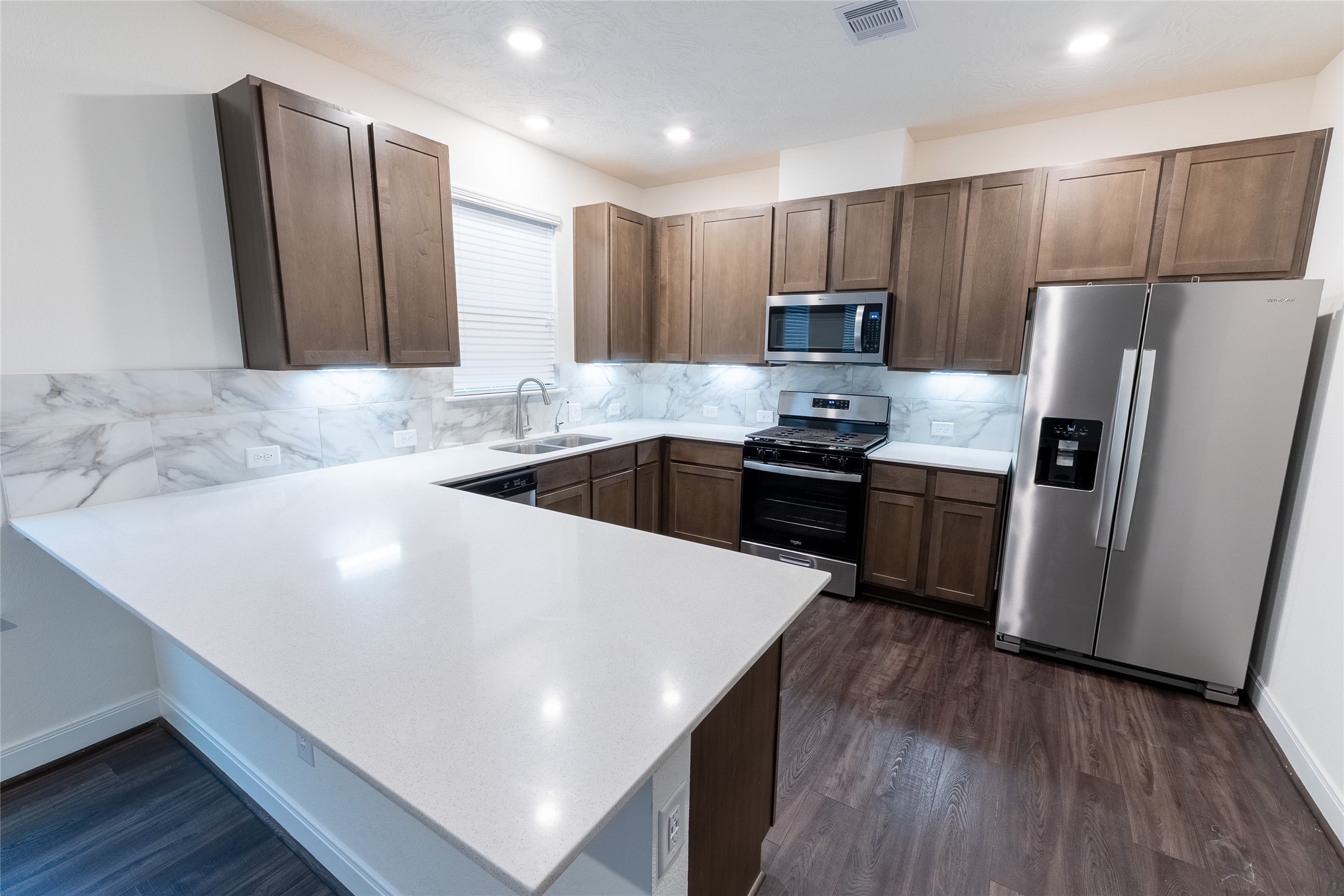 27646 Mesabe Drive Magnolia, TX 77354 - Photo 6 of 24 a kitchen with kitchen island granite countertop a sink a stove a refrigerator and cabinets