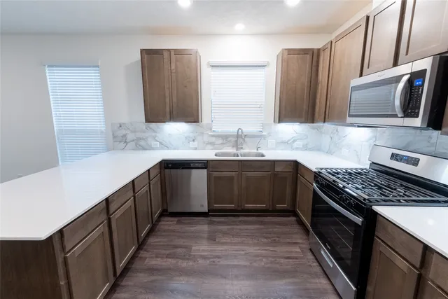 a kitchen with stainless steel appliances granite countertop a sink stove and refrigerator