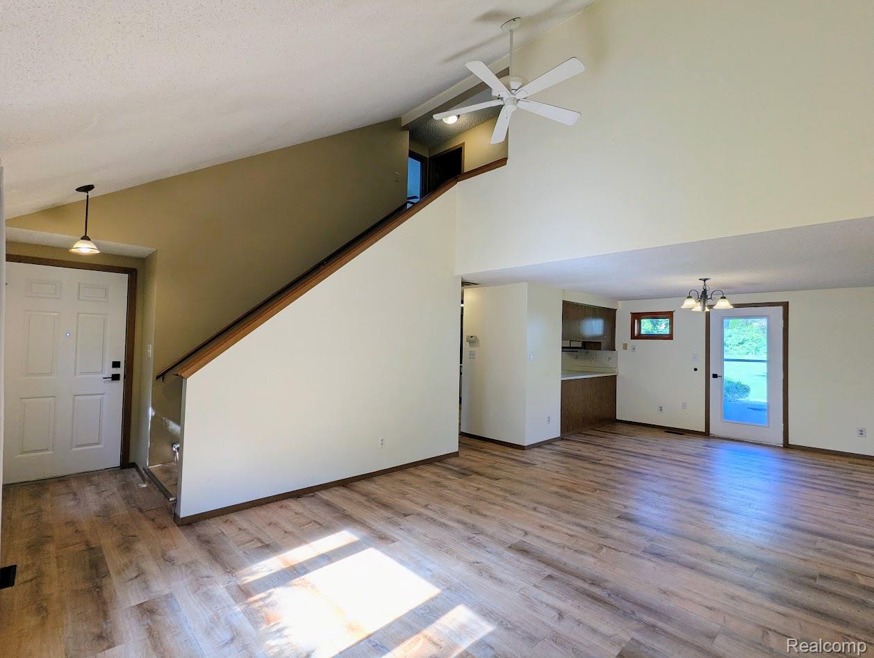 2316 Crescent Lake Road Waterford, MI 48329 - Photo 4 of 17 Spacious living area featuring wood-finish flooring, a soaring vaulted ceiling, and a modern ceiling fan