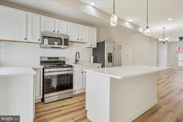 a kitchen with stainless steel appliances a stove a sink and a refrigerator